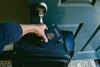 Hand opening door with US passport on top of suitcase