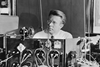 An image showing Ernest Orlando Lawrence at the controls of the 37-inch cyclotron around 1938