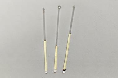 Three thin glass tubes that have been sealed containing a pale yellow liquid