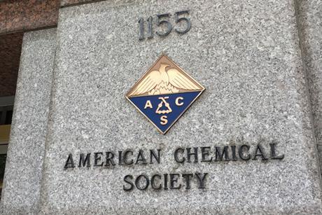 A sign and a crest on a marble building for the American Chemical Society