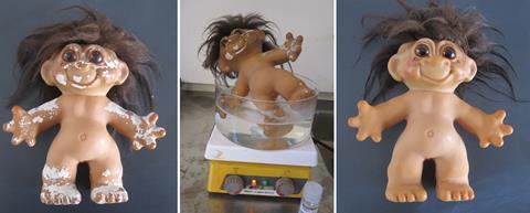 Troll dolls with white plasticiser deposits being cleaned